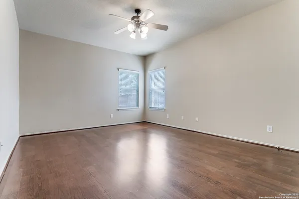 an empty room with wooden floor and window