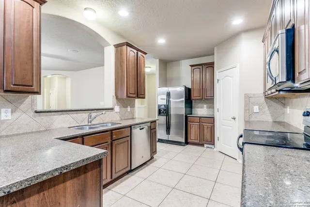 a kitchen with stainless steel appliances granite countertop a sink stove and refrigerator