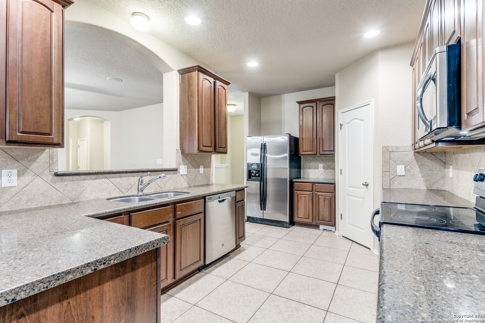3418 Alonzo Fields Converse, TX 78109 - Photo 15 of 36 a kitchen with stainless steel appliances granite countertop a sink stove and refrigerator