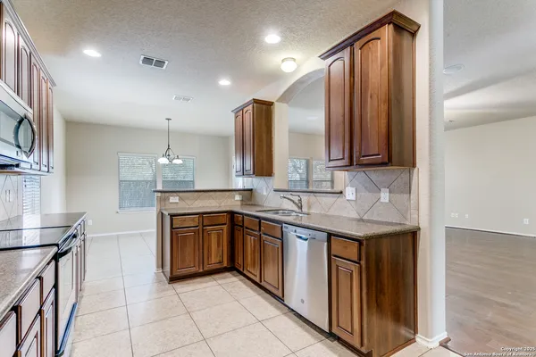 a kitchen with stainless steel appliances granite countertop a sink and cabinets