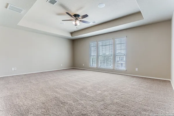 an empty room with windows and fan
