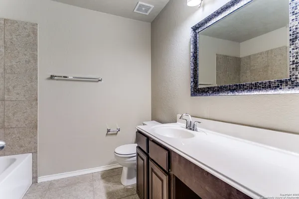 a bathroom with a sink a toilet and a mirror