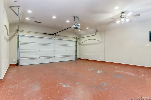 en empty room with windows and ceiling fan