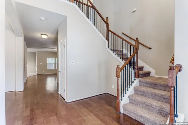 a view of a hallway with wooden floor and entryway