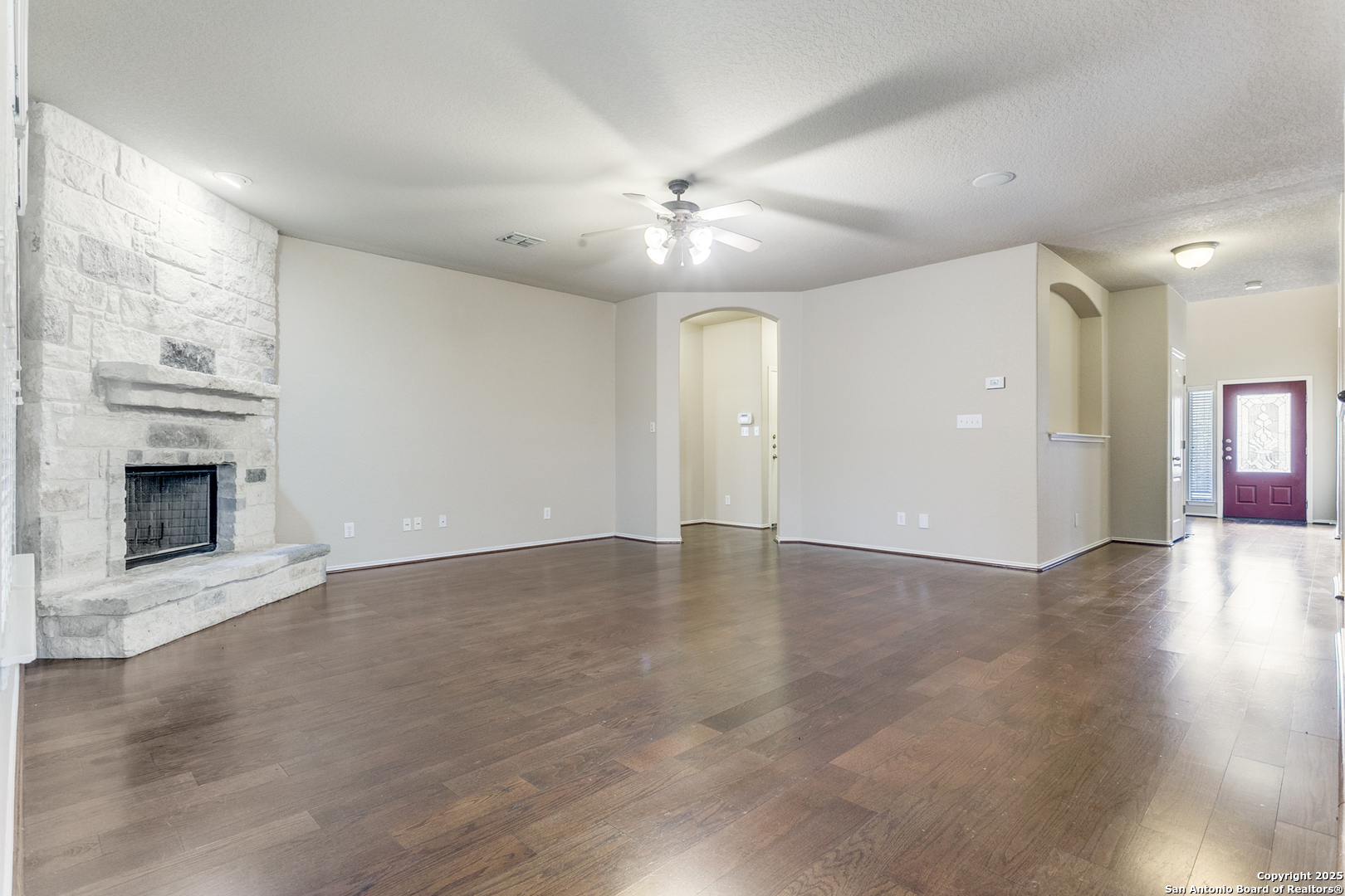 3418 Alonzo Fields Converse, TX 78109 - Photo 7 of 36 an empty room with wooden floor fireplace and ceiling fan