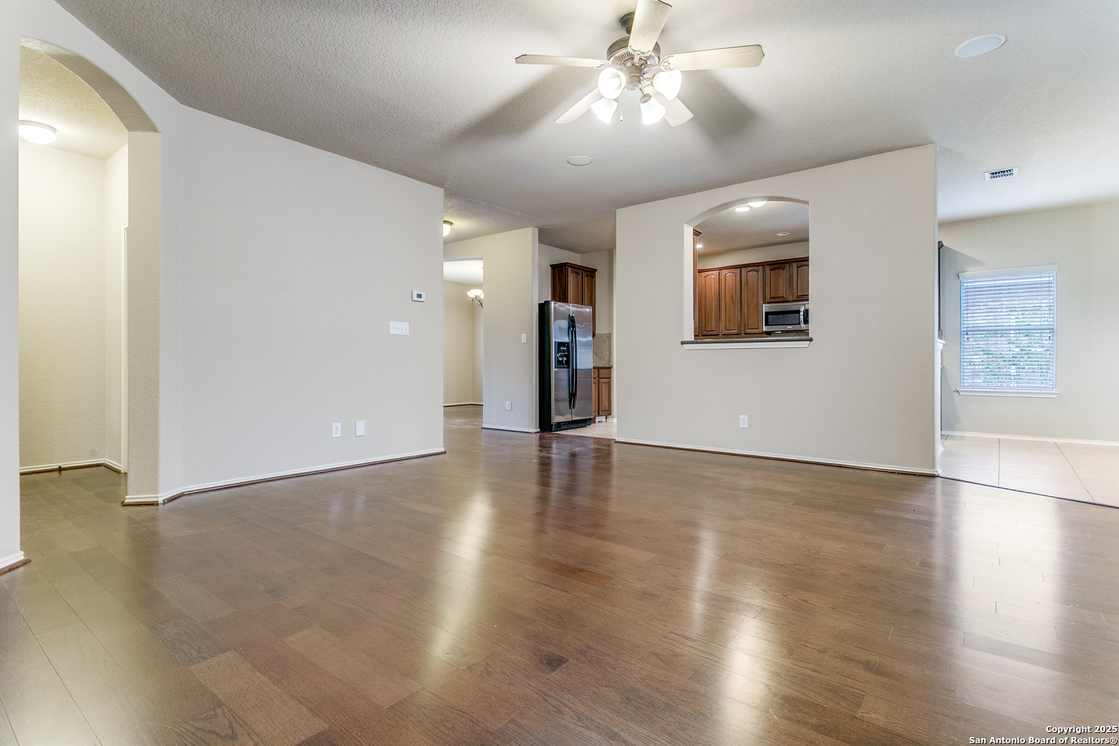 3418 Alonzo Fields Converse, TX 78109 - Photo 10 of 36 a view of an empty room with wooden floor and a ceiling fan