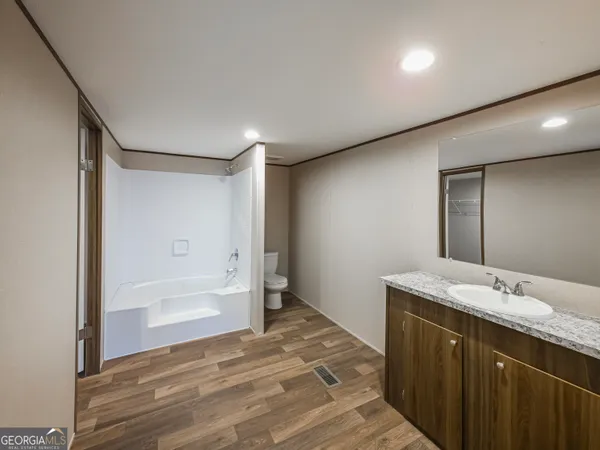 a bathroom with a granite countertop sink mirror and a bathtub