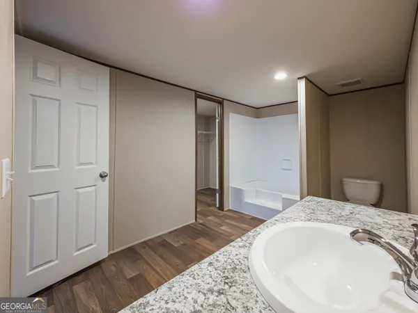 a spacious bedroom with a bed and a dresser