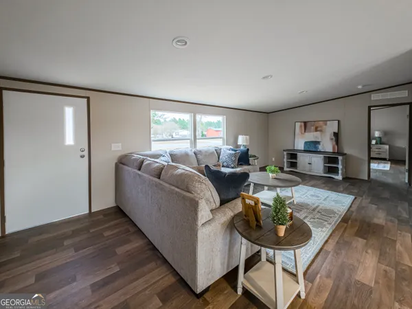 a living room with furniture and a wooden floor