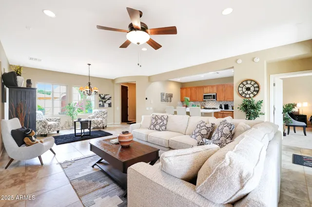 a living room with furniture ceiling fan and a large window