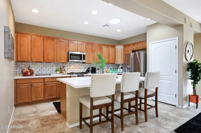 a kitchen with a table chairs refrigerator and microwave