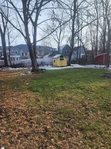 a view of pool with a yard and large trees