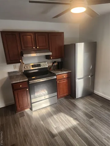 a kitchen with wooden floors and stainless steel appliances