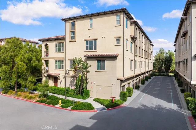 a view of a white house with many windows and plants