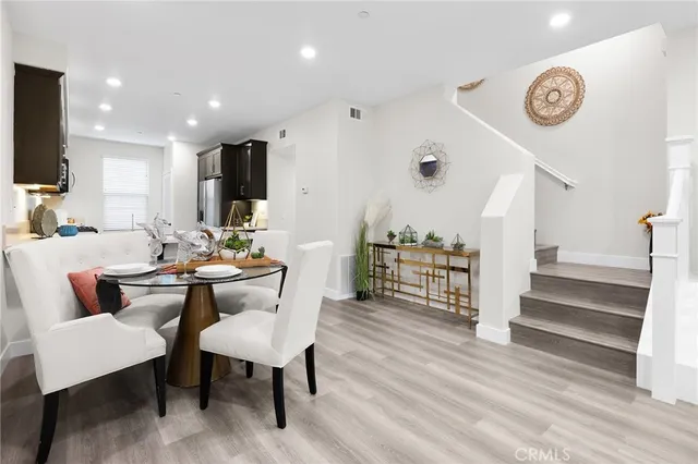 a dining room with furniture a chandelier and wooden floor