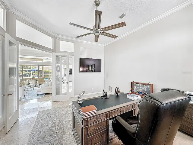 a room with a chandelier furniture a ceiling fan and a window