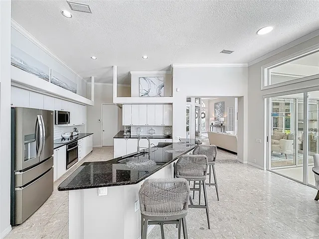 a kitchen with stainless steel appliances granite countertop a refrigerator and a stove top oven