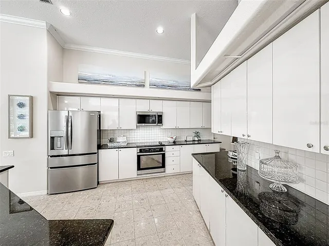 a large kitchen with stainless steel appliances granite countertop a stove sink and refrigerator