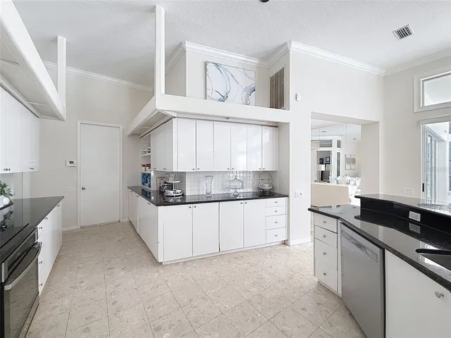 a kitchen with granite countertop white cabinets and white appliances