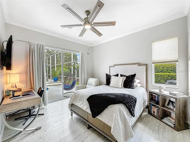 a bedroom with a bed a large window and a flat tv screen