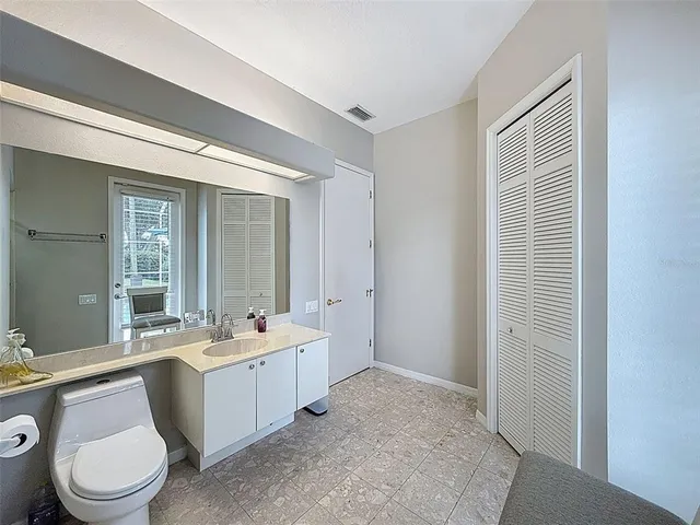 a bathroom with a double vanity sink toilet and mirror