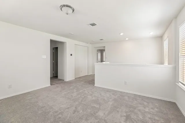 an empty room with a window and a ceiling fan