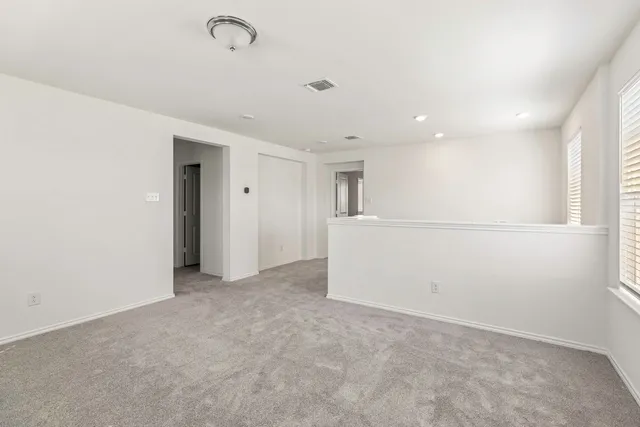 an empty room with a window and a ceiling fan
