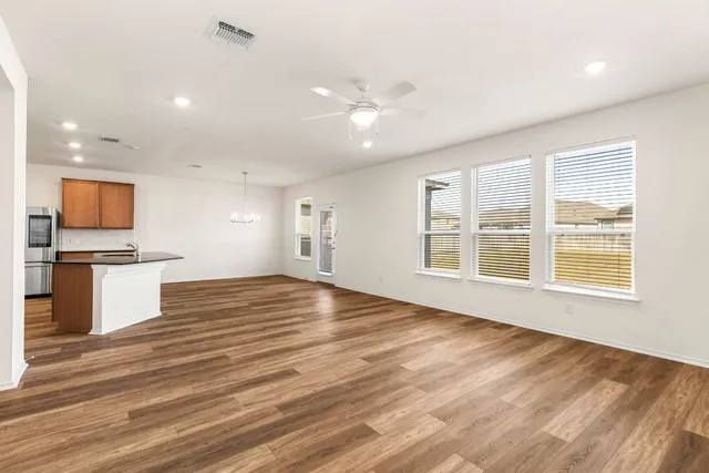 a view of kitchen with kitchen island a sink wooden floor and a refrigerator
