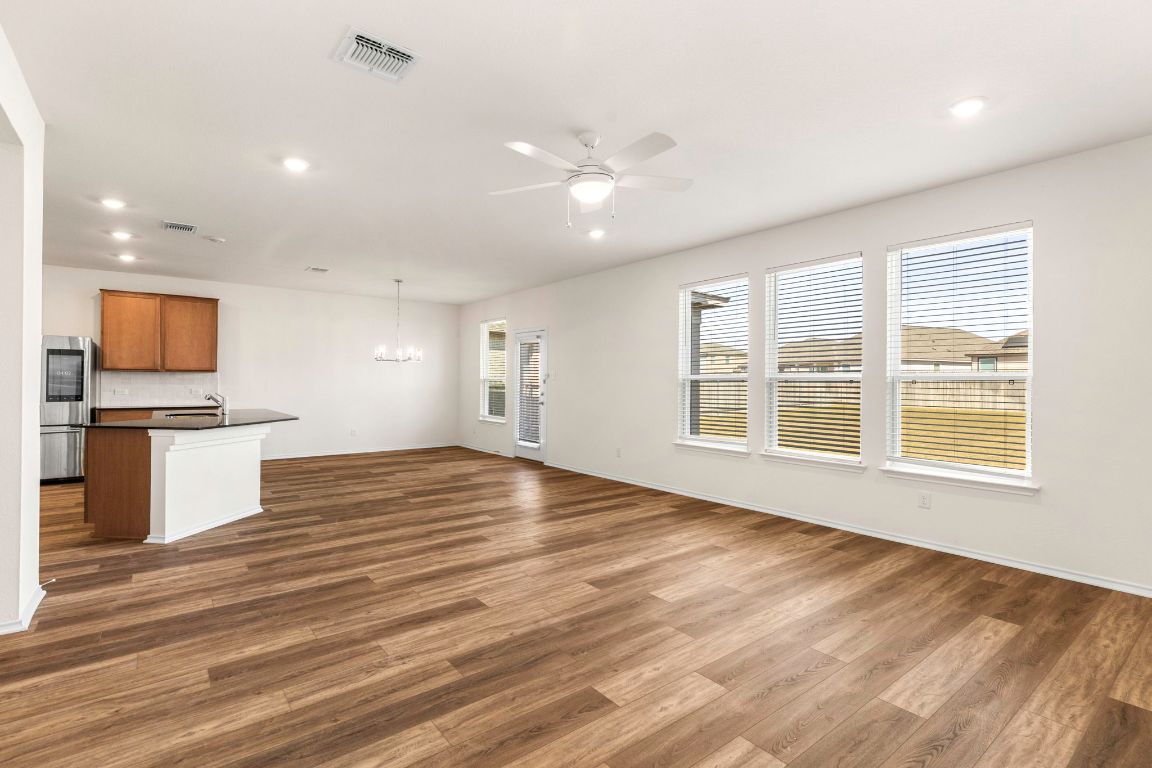 213 Skipping Stone Run Georgetown, TX 78628 - Photo 6 of 31 a view of empty room with wooden floor and kitchen view