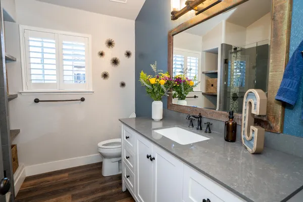 a bathroom with a granite countertop sink mirror and a toilet