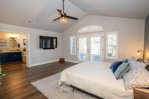 a spacious bedroom with a large bed and a chandelier