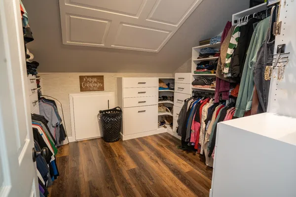 a view of walk in closet with clothes and shoes
