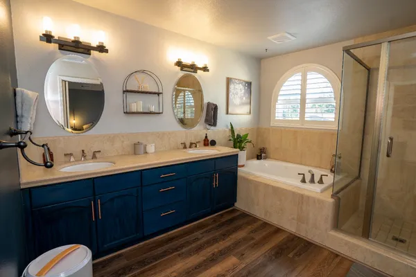 a spacious bathroom with a granite countertop tub a double vanity sink and a mirror