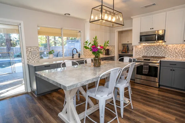 a view of a dining room with furniture a chandelier and wooden floor