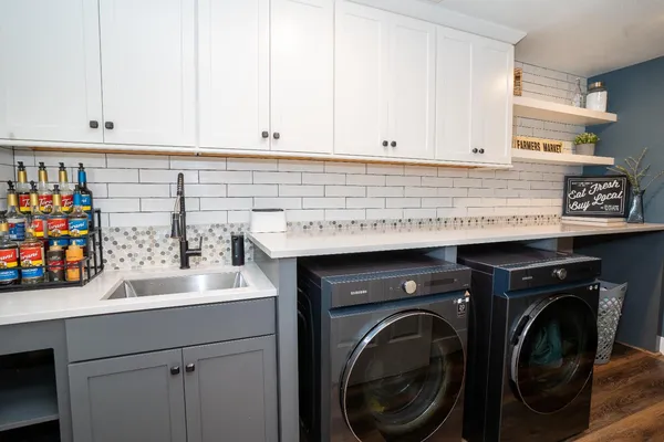 a utility room with stainless steel appliances washer and dryer