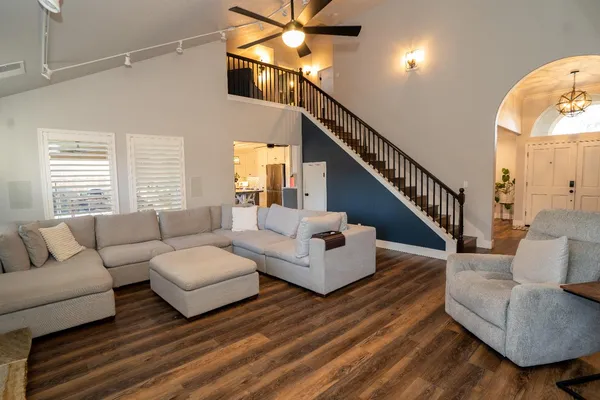 a living room with couches a coffee table and a chandelier
