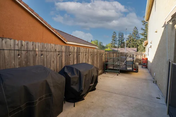 a backyard of a house with barbeque oven and outdoor seating