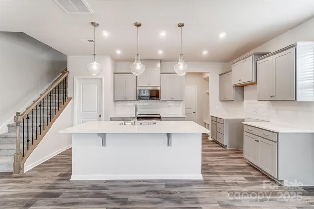 a kitchen with kitchen island a sink stainless steel appliances and cabinets