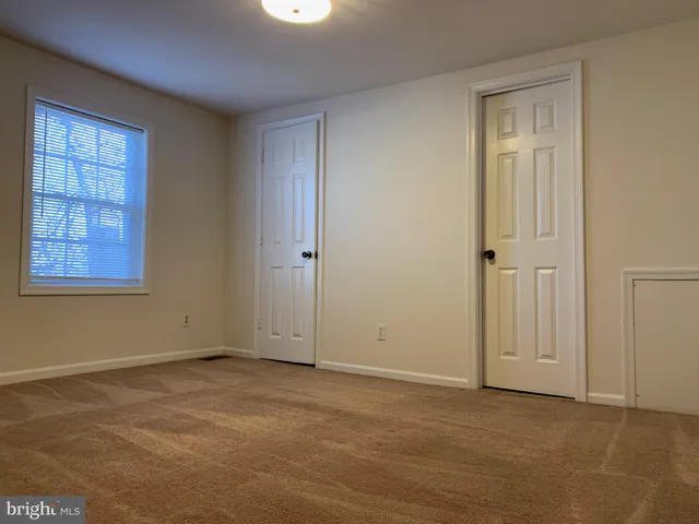 an empty room with windows and closet