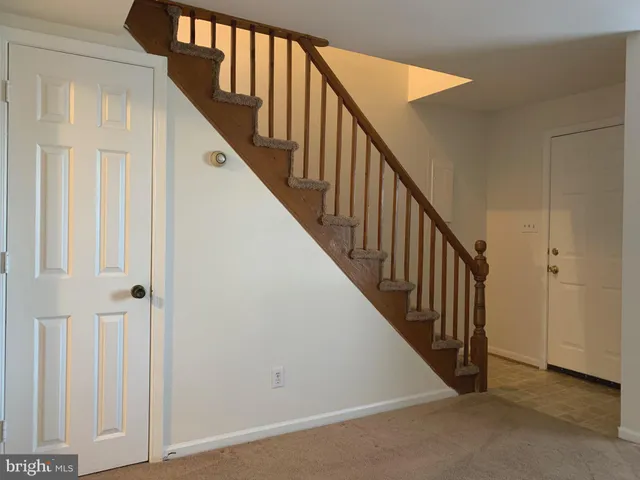 a view of staircase with lots of frames on wall and wooden floor