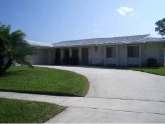 896 Ne Port Palm Bay, FL 32905 - Photo 1 of 9 a view of a house with a yard and garage