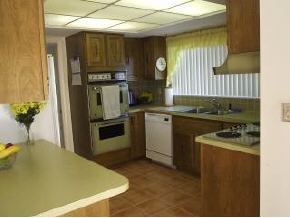 896 Ne Port Palm Bay, FL 32905 - Photo 4 of 9 a kitchen with stainless steel appliances granite countertop a sink a stove and a refrigerator