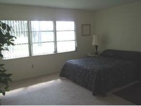 896 Ne Port Palm Bay, FL 32905 - Photo 5 of 9 a bed sitting in a bedroom next to a window