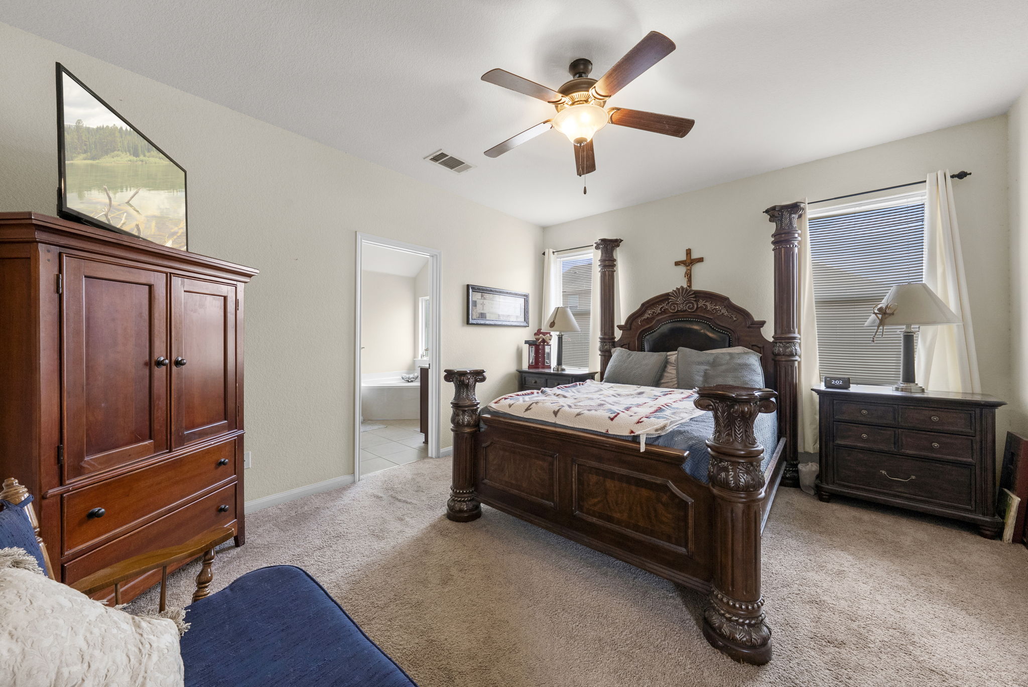 1617 Treeta Trail Kyle, TX 78640 - Photo 8 of 39 Bedroom with light colored carpet, a ceiling fan, and ensuite bathroom
