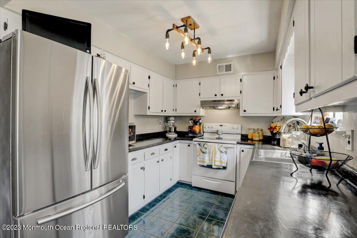 367 Middlewood Road Middletown, NJ 07748 - Photo 7 of 21 a kitchen with stainless steel appliances granite countertop a refrigerator a sink dishwasher a stove and white cabinets with wooden floor