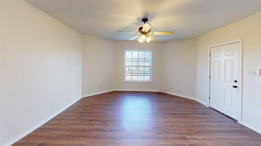 224 West Hull Street, Unit B Denison, TX 75020 - Photo 3 of 13 Spare room featuring dark wood-type flooring and ceiling fan