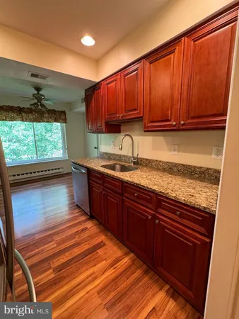 a kitchen with stainless steel appliances granite countertop wooden cabinets a sink and dishwasher