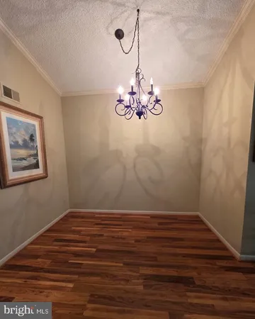 a view of a room with wooden floor and chandelier