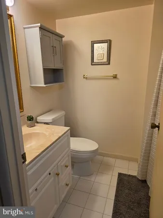 a bathroom with a granite countertop toilet and a sink