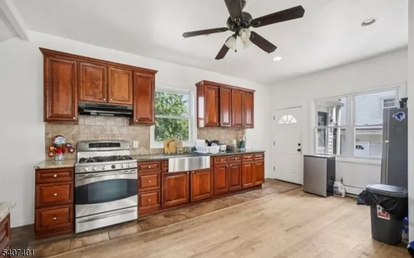 a kitchen with cabinets wooden floor and stainless steel appliances